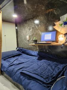 胡志明市D-Dorm Home的一间卧室配有一张床铺,书桌上配有一台电脑