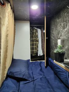 胡志明市D-Dorm Home的一间卧室配有蓝色的床和镜子
