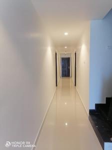 根尼亚古马里Shanmuga Residency的白色墙壁和白色的长地板走廊