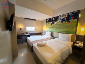 日惹日惹考德迭拉卡德迪卡黛维酒店的酒店客房设有两张床,墙上挂有绘画作品