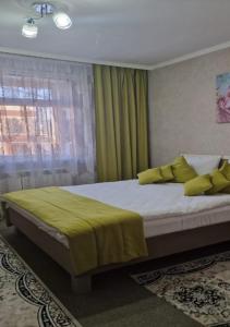 卡拉甘达Hotel Miss Mari的一间卧室配有一张带黄色枕头的床和一扇窗户