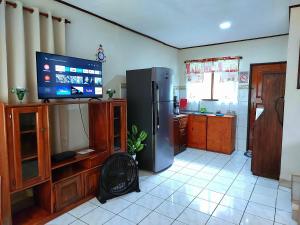 蓬塔雷纳斯Casa equipada en el centro de Puntarenas的带冰箱的厨房和平面电视。