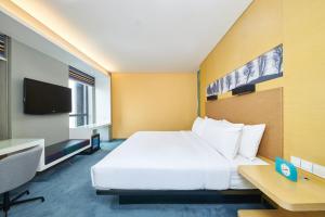 郑州郑州上街雅乐轩酒店 的酒店客房设有一张大床和一张书桌。