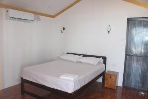 卡纳科纳Nikhil's Beach Cottages的一间卧室配有一张带白色床单的床和一扇窗户。
