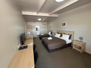 塞杜纳高速公路一号汽车旅馆的一间卧室配有一张床、一张沙发和一台电视