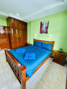 卡塔海滩BT hotel Kata Beach的一间卧室配有蓝色大床和蓝色枕头
