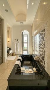 麦纳麦Raffles Al Areen Palace Bahrain的一间大浴室,内配黑色浴缸