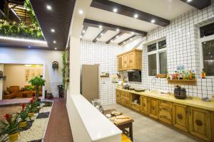 腾冲腾冲和顺古镇崇尚坊客栈的一间铺有白色瓷砖的大厨房,配有木制橱柜