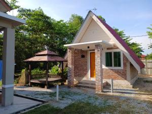 巴西富地Zainab Cottage的一个小房子,设有门廊和雨伞
