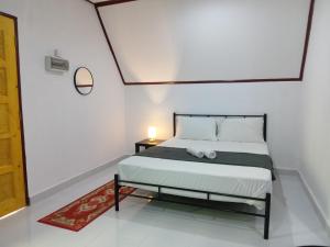 巴西富地Zainab Cottage的一间卧室配有一张床和一张桌子上的台灯