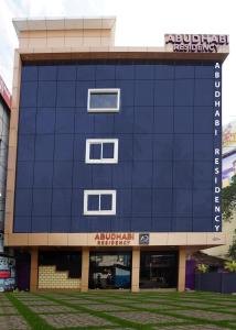 帕拉克卡德ABUDHABI RESIDENCY的一座蓝色的大建筑,上面有标志