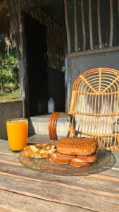 苏丹巴特利Lotus Jewel Forest Camping的桌上的三明治和一杯橙汁