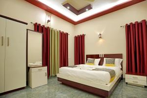 安巴拉瓦亚尔Loreal Luxury Holiday villa的一间卧室配有一张带红色窗帘和镜子的床