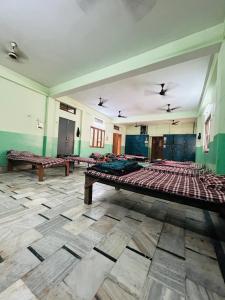 瓦拉纳西Satsang Lodge的大房间,里面设有几张床
