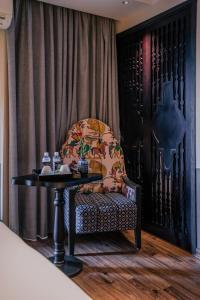 河内Hanoi Center Silk Classic Hotel & Travel的椅子,桌子,带窗帘的房间