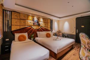 河内Hanoi Center Silk Classic Hotel & Travel的配有白色床单的酒店客房内的两张床