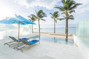 湄南海滩Explorar Koh Samui - Adults Only Resort and Spa的一个带两把椅子和一把遮阳伞的庭院和海滩