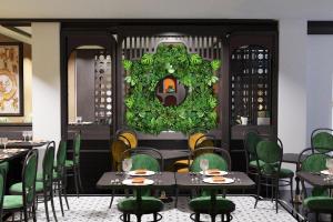 河内Hanoi Center Silk Classic Hotel & Travel的用餐室配有桌子和绿色椅子