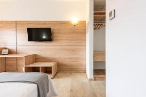 阿尔姆尼卡阿尔穆涅卡托沃索酒店的一间卧室配有一张床,墙上配有电视
