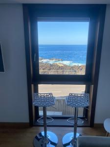 加拉奇科Modern sea front apartment in Garachico 3的窗户享有海景,配有两把椅子