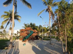 塞拉莱Maxim Hawana Salalah的棕榈树公园内一个带滑梯的游乐场