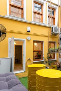 伊斯坦布尔La Villa Gardenia : 4Br Villa with Private Garden的黄色的建筑,配有黄色的桌子和椅子