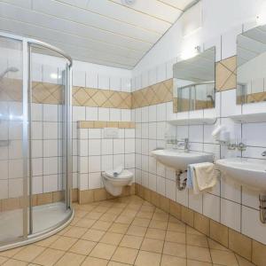 瓦格赖恩Appartement Nr 6 Alpenstern的一间带两个盥洗盆、淋浴和卫生间的浴室