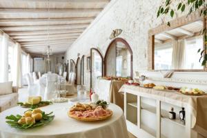 费尔莱恩Masseria Cucuruzza Boutique Hotel的用餐室配有餐桌和食物