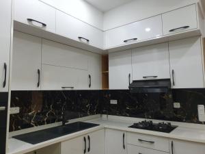 哈马马特Comfystay的厨房配有白色橱柜和黑色台面