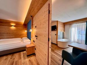 卡纳泽伊Dolomiti Luxury Mountain View的卧室配有床和浴缸
