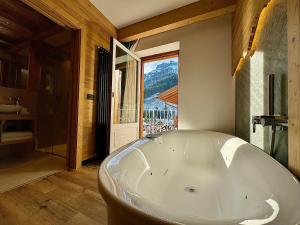 卡纳泽伊Dolomiti Luxury Mountain View的带窗户的浴室内的白色大浴缸