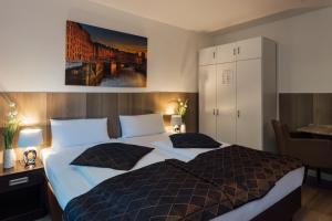 汉堡Hotel Hanseat Hamburg的一间卧室配有一张大床和两个枕头