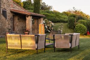 科尔托纳Mulino a Vento的院子里有三把椅子和一张桌子
