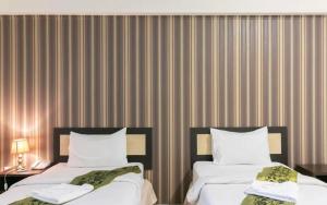 莱卡邦B9 Airport Resident的酒店客房设有两张床和条纹墙