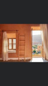 阿伊特本哈杜Tigmi Hamid的一间设有床铺和窗户的客房,配有梯子
