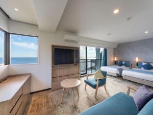 东伊豆町Atagawa Ocean Resort的酒店客房设有两张床和电视。