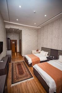 杜尚别VATAN DUSHANBE HOTEL的酒店客房设有两张床和电视。