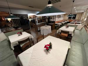 奥布施泰希Pension Alpina的餐厅设有桌椅,并种有鲜花