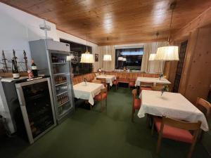 奥布施泰希Pension Alpina的一间带桌椅和冰箱的餐厅