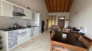 康提Chathu Holiday Home的厨房以及带桌椅的起居室。