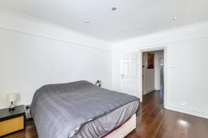 伦敦钱塞瑞之阁楼私人公寓的一间铺有木地板的白色卧室,配有一张床