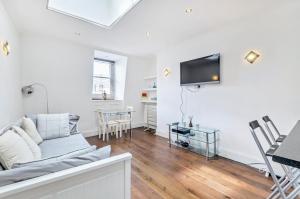 伦敦钱塞瑞之阁楼私人公寓的客厅配有沙发和墙上的电视