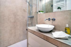 佩尔蒂Les Nids de la Diane - Appart'Conforts的一间带水槽和玻璃淋浴的浴室