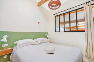 佩尔蒂Les Nids de la Diane - Appart'Conforts的卧室配有白色的床和窗户。