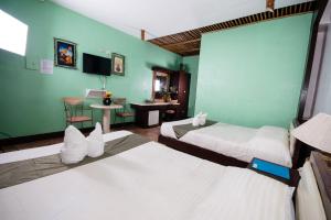 San RemigioSan Remigio Beach Club的酒店客房设有两张床和一张桌子。