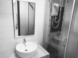 卢穆特MARINA HEIGHTS HOTEL 3 BEDROOMS SWIMMING POOL VIEW LUMUT MANJUNG的白色的浴室设有水槽和镜子