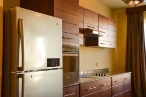 加利布港Port Ghalib Marina Residence Suites的带木柜的厨房内的不锈钢冰箱