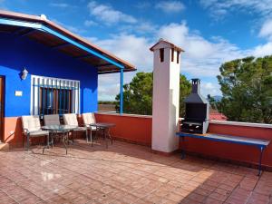 巴尔德佩尼亚斯La Venta de las Estrellas Casas Rurales的蓝色房屋内带桌子和炉灶的庭院
