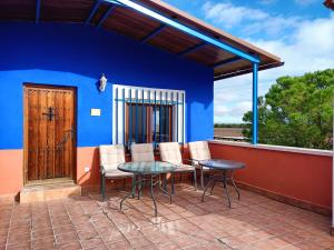 巴尔德佩尼亚斯La Venta de las Estrellas Casas Rurales的一个带桌椅和蓝色墙壁的庭院