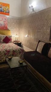 拉巴特DAR LALLA Aicha 2的一间卧室配有一张床、一张桌子和一张沙发